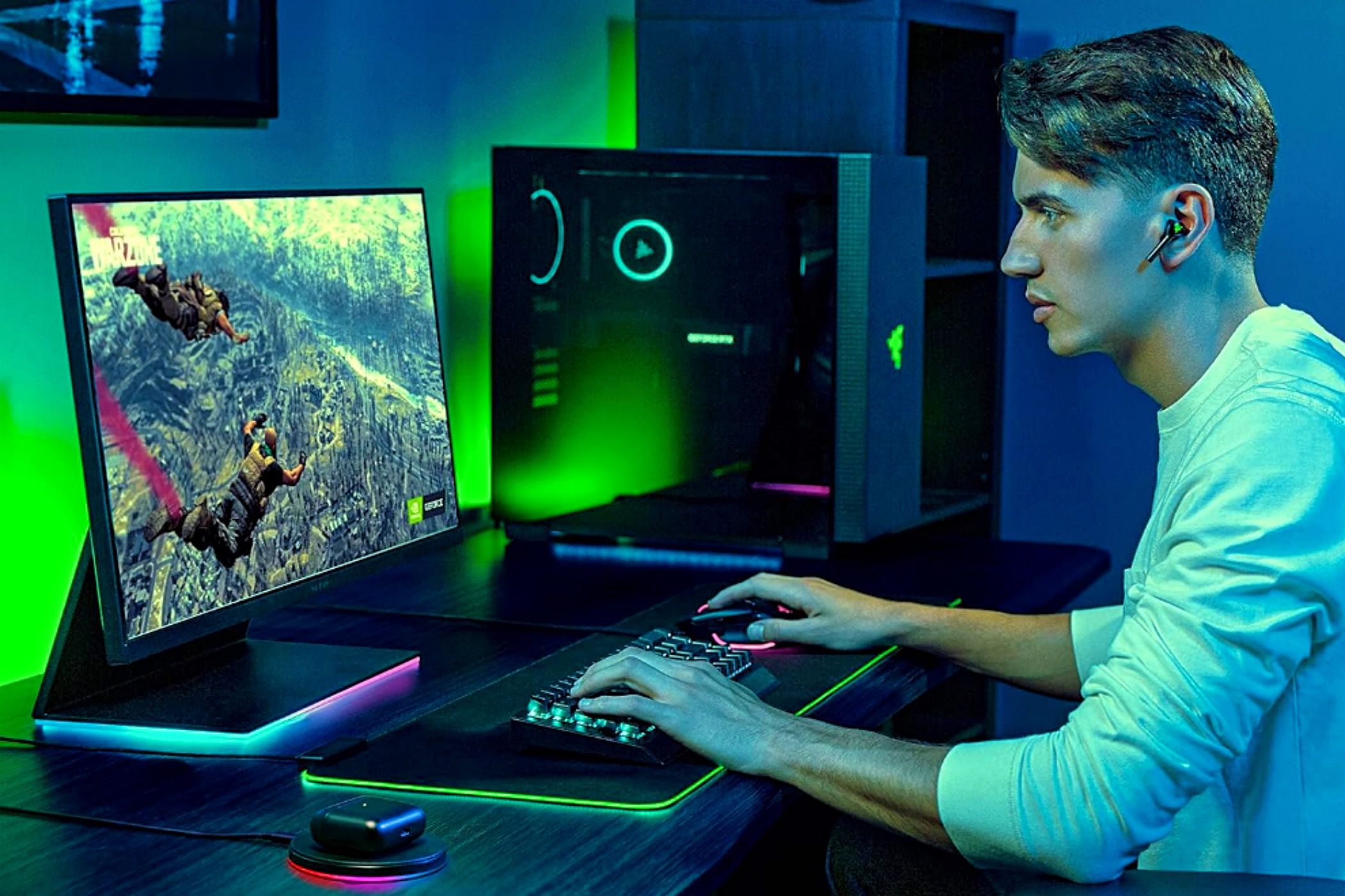 A man wearing Razer Hammerhead Pro HyperSpeed earbuds to play games on a PC.