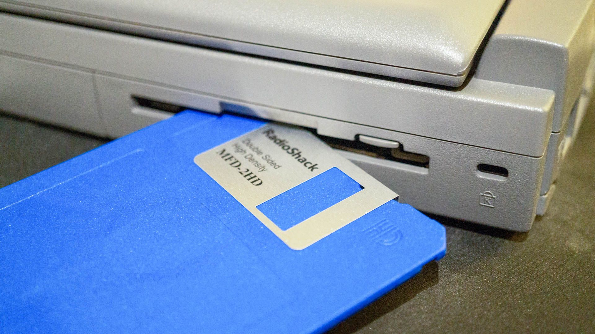 Floppy disk and drive on laptop.
