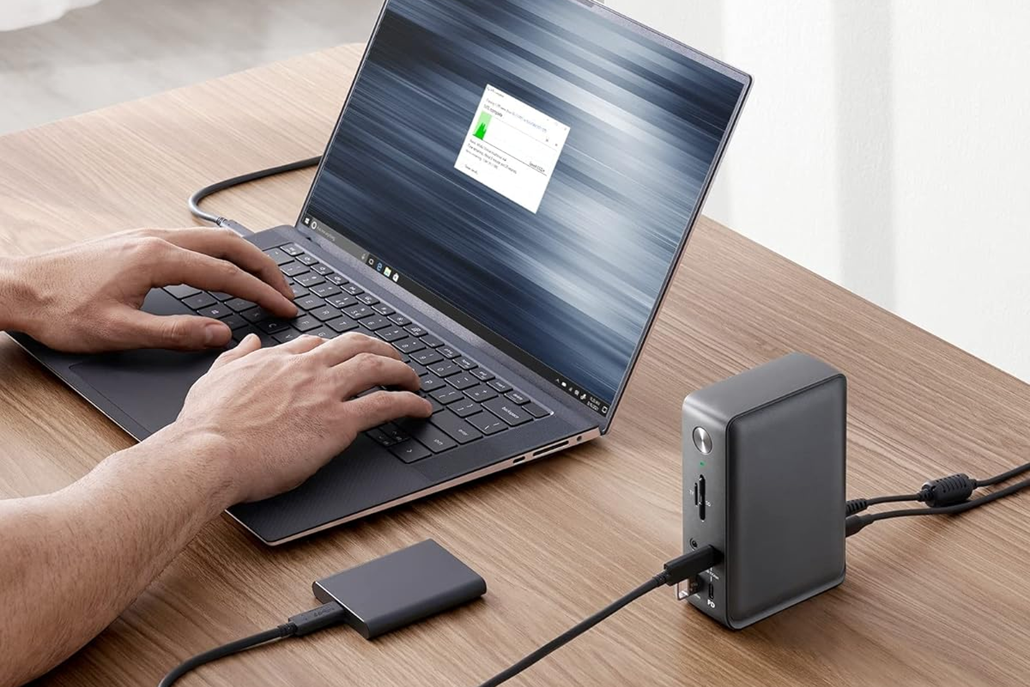 Anker 575 13-in-1 USB-C hub sitting on a desk plugged into a laptop