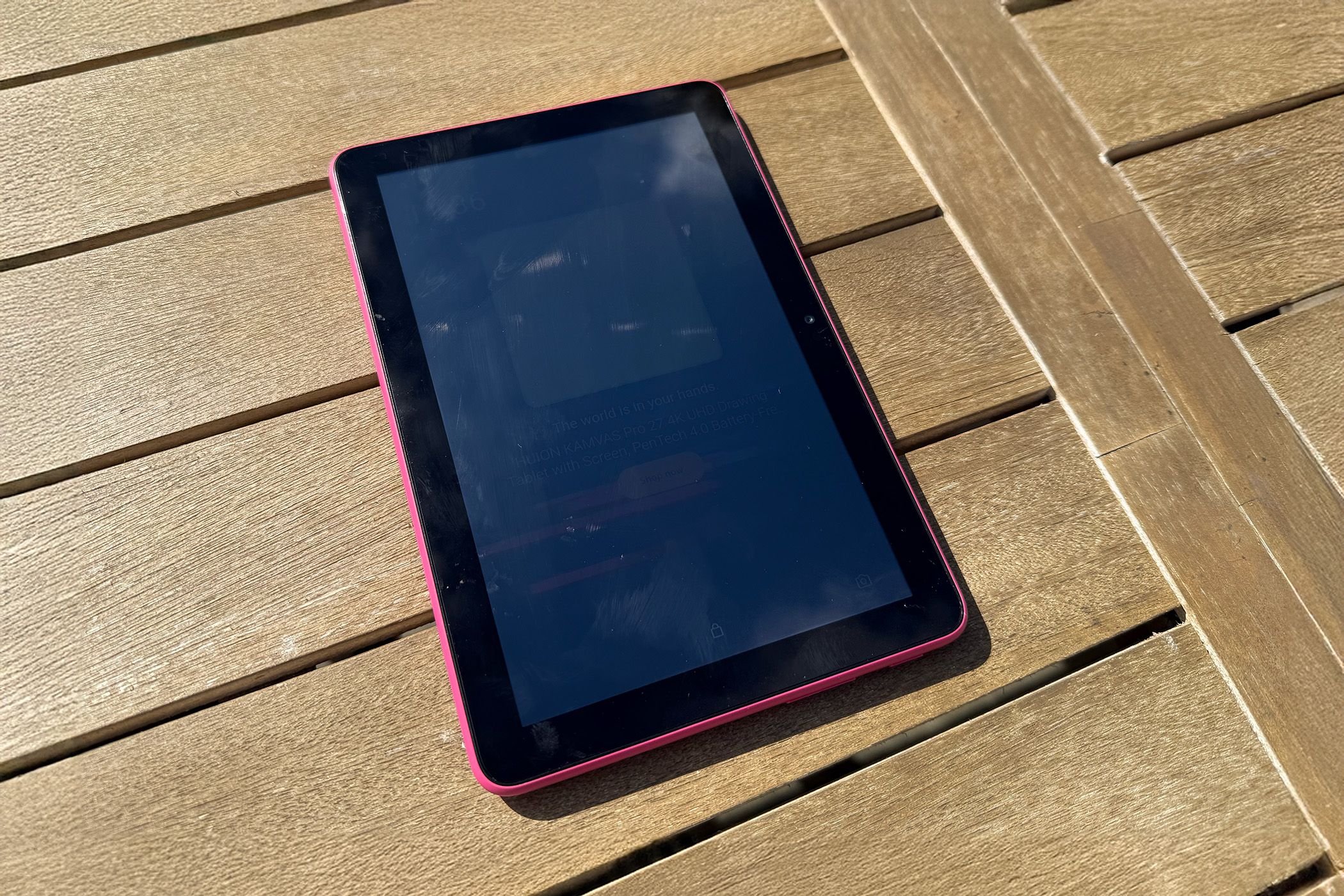 Amazon Kindle Fire HD 8 on a table showing a screen washed out from the brightness of the sun. 