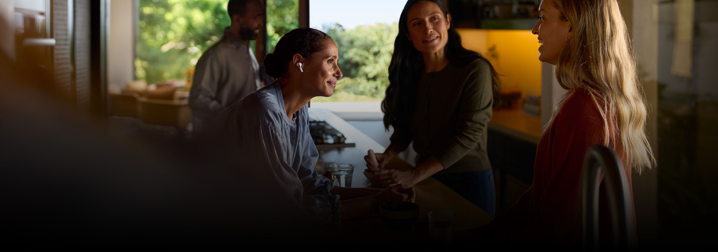 An image from Apple's hearing aid marketing showing a woman wearing AirPods in conversation.