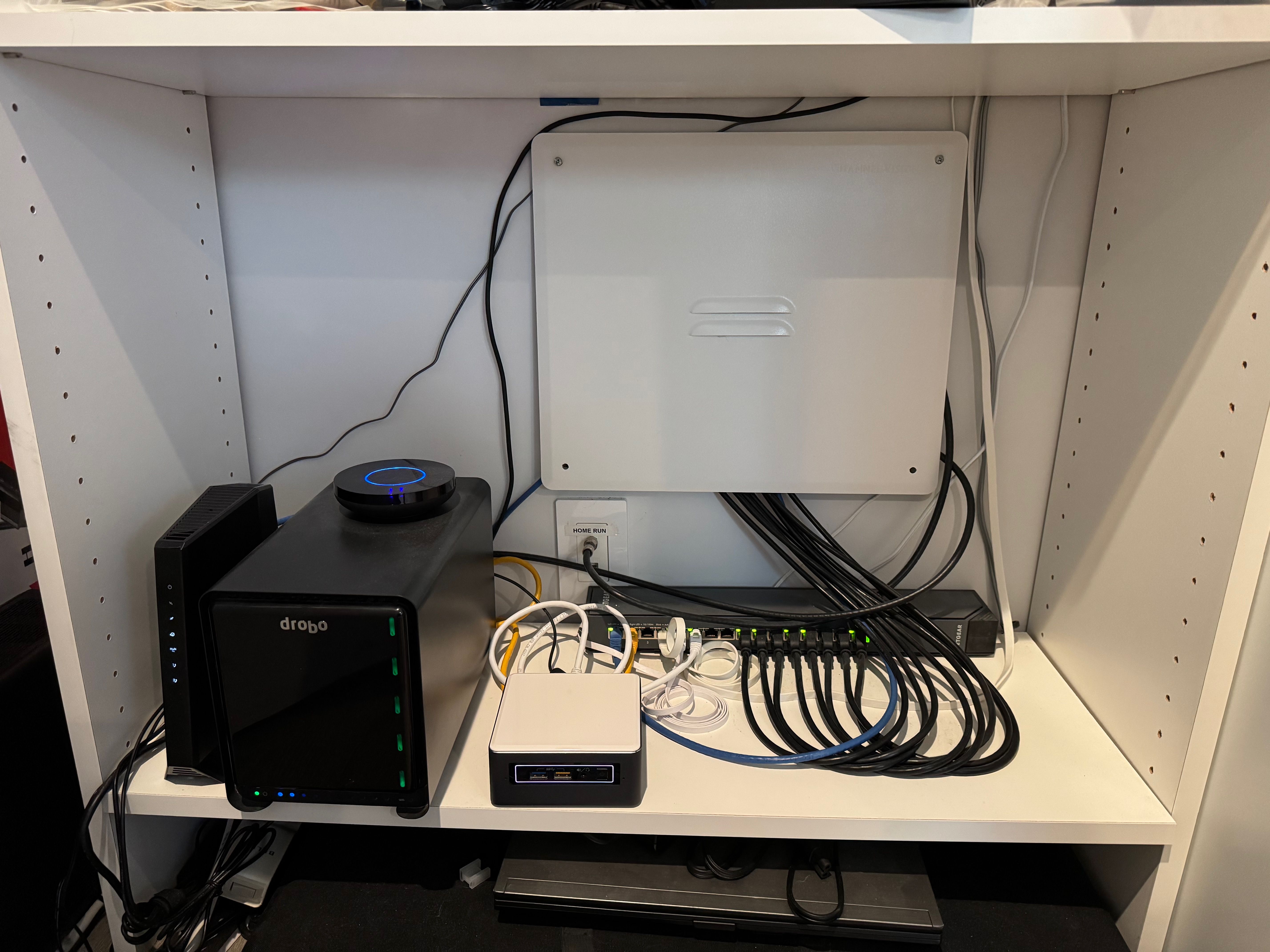 Closet shelf with cable modem, switch, NAS, smart hubs, and server.