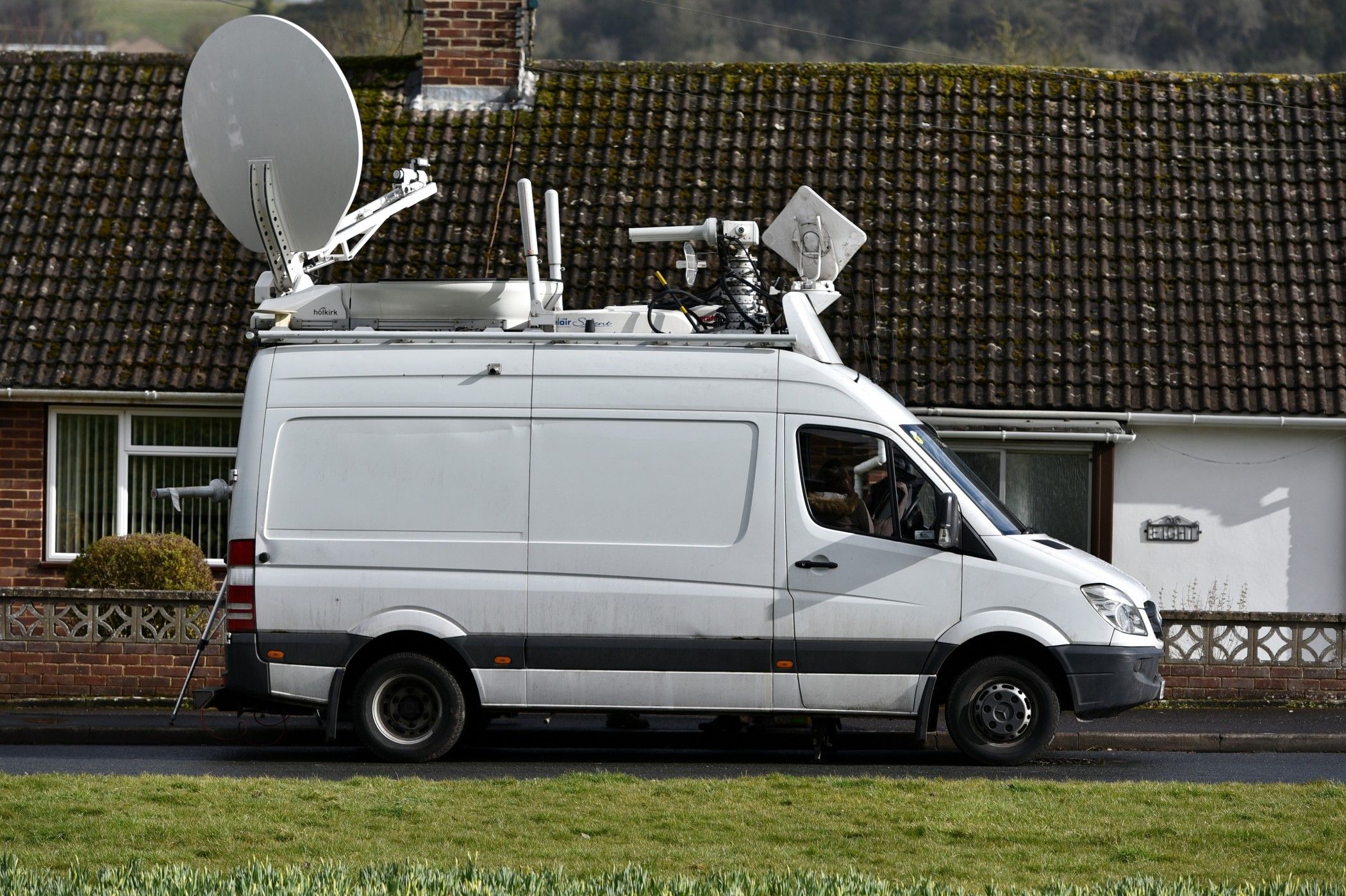 An outside broadcasting van is seen parked near a crime scene.