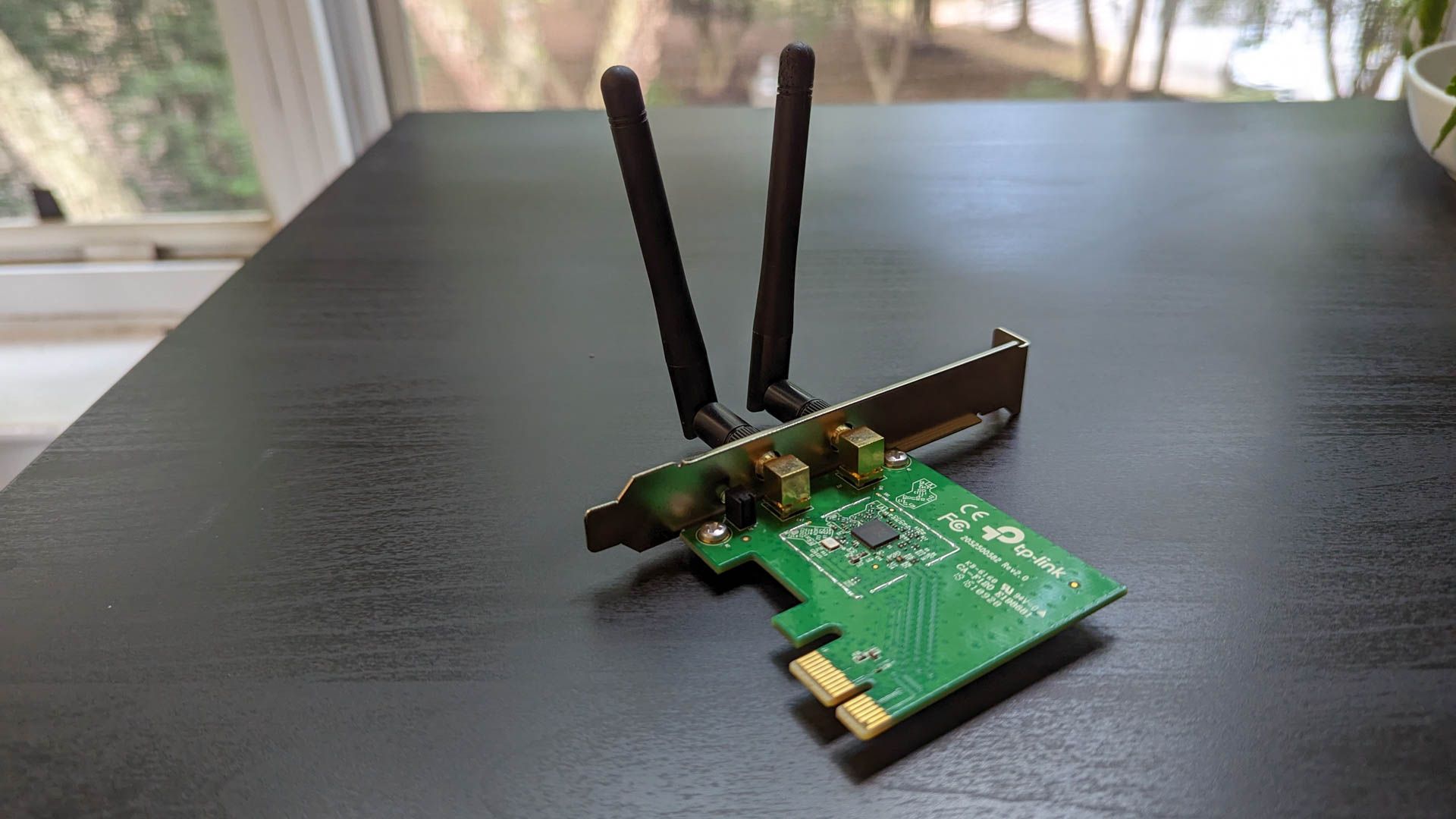 A PCIe Wi-Fi adapter sitting on a table. 