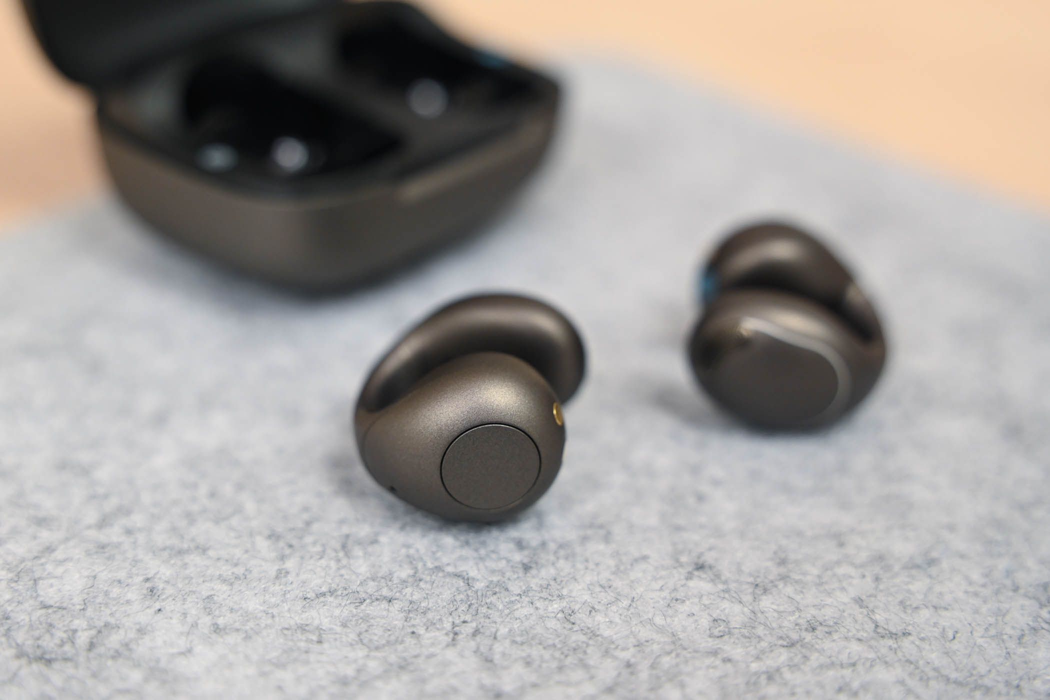 A pair of Soundcore C40i earbuds near their case.