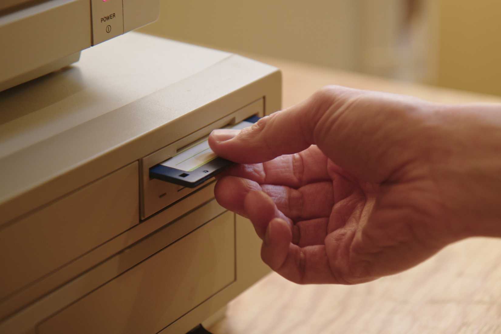Hand inserting and ejecting Floppy Disk into vintage Commodore Amiga 2000.