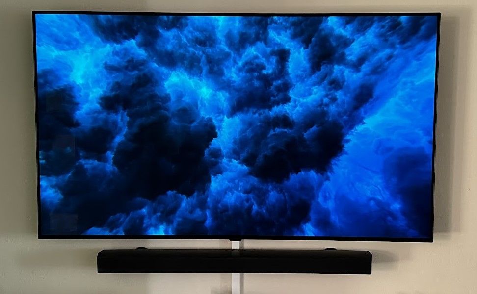 LG CS OLED TV wall-mounted with Samsung soundbar.