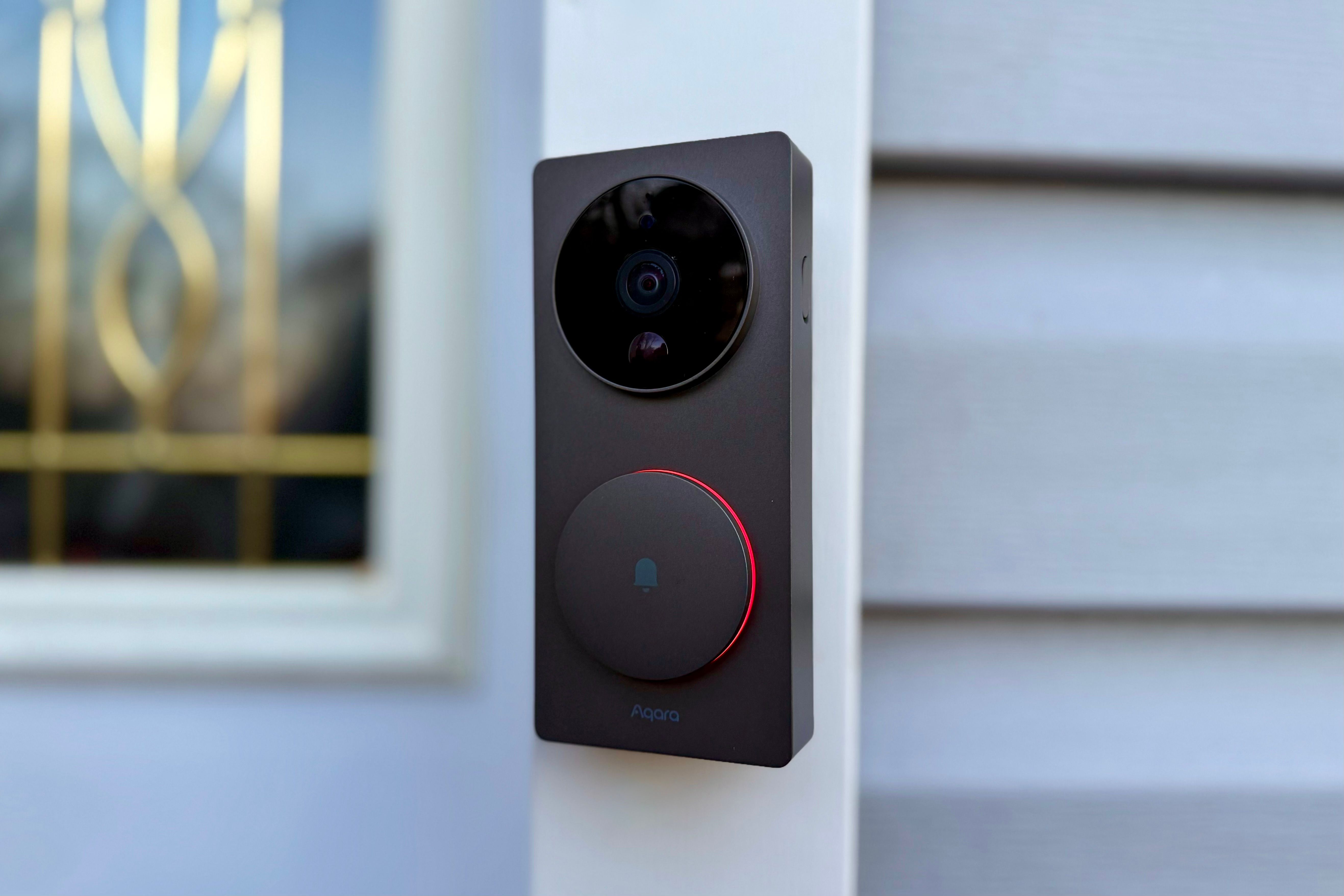 Aqara g$ Doorbell built into grey and white siding by front door.