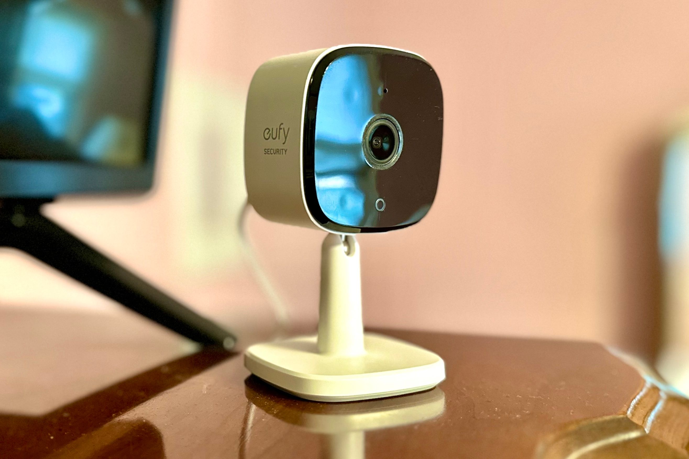 Eufy Security Indoor Cam C120 on a brown wooden surface.