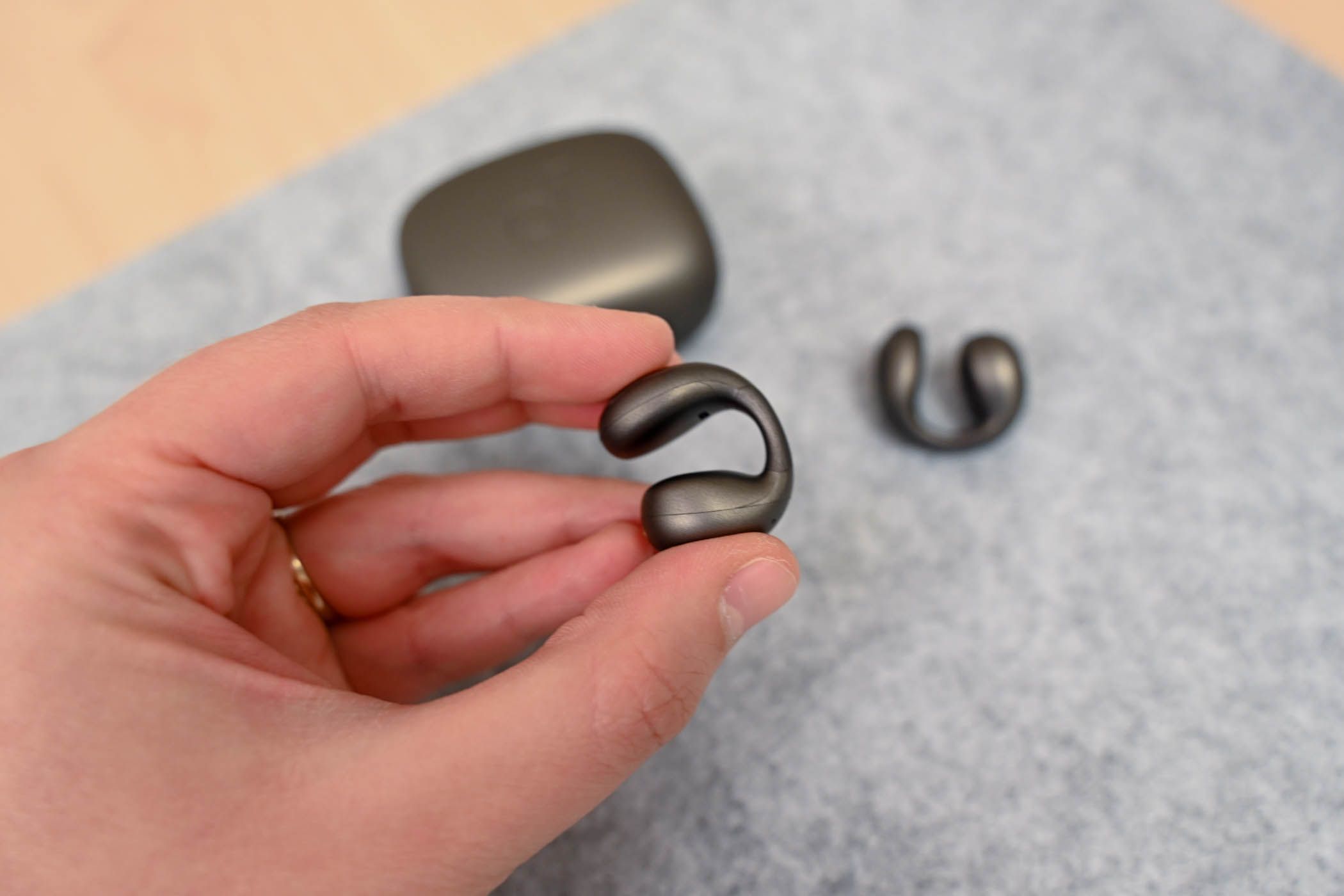 Person holding a Soundcore C40i earbud.