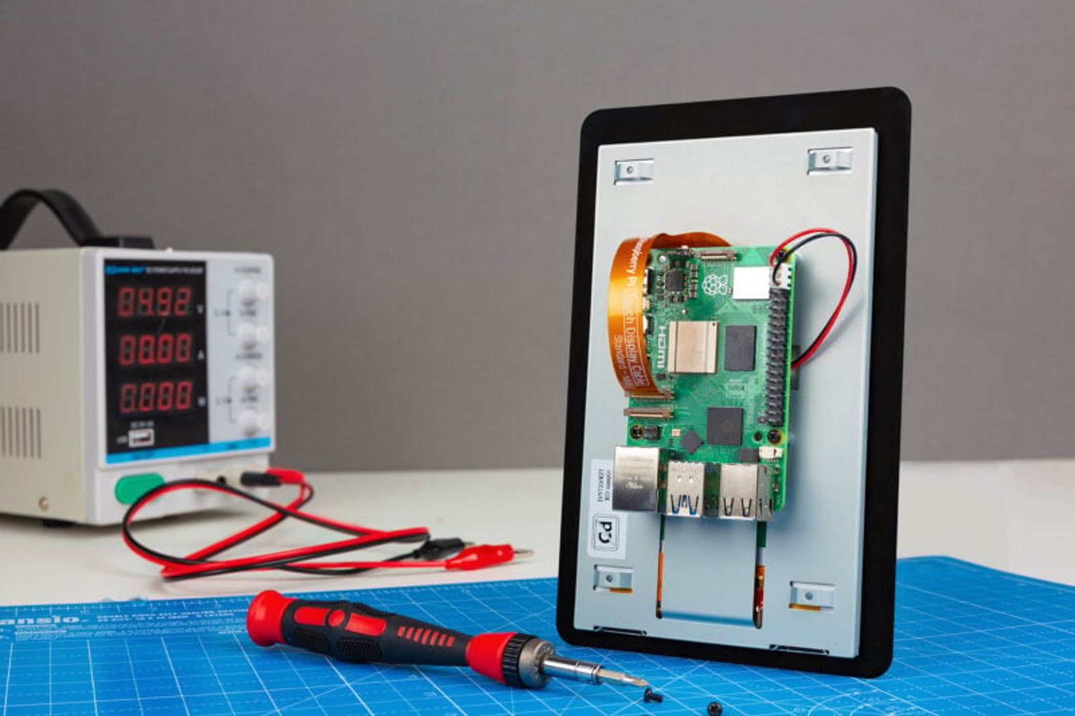 Raspberry Pi Touch Display 2 assembled on table, there is a device to work on it nearby.