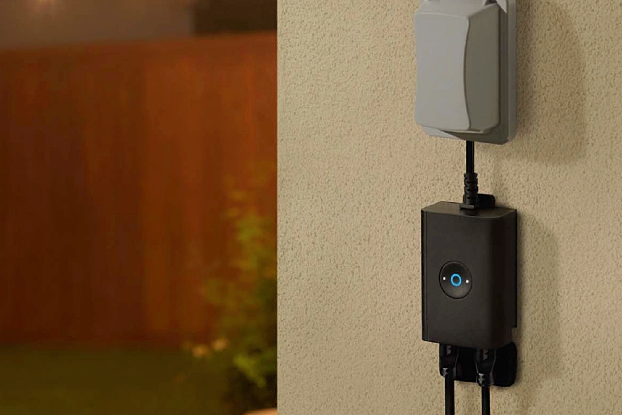 A Ring Outdoor Smart Plug mounted on a wall.