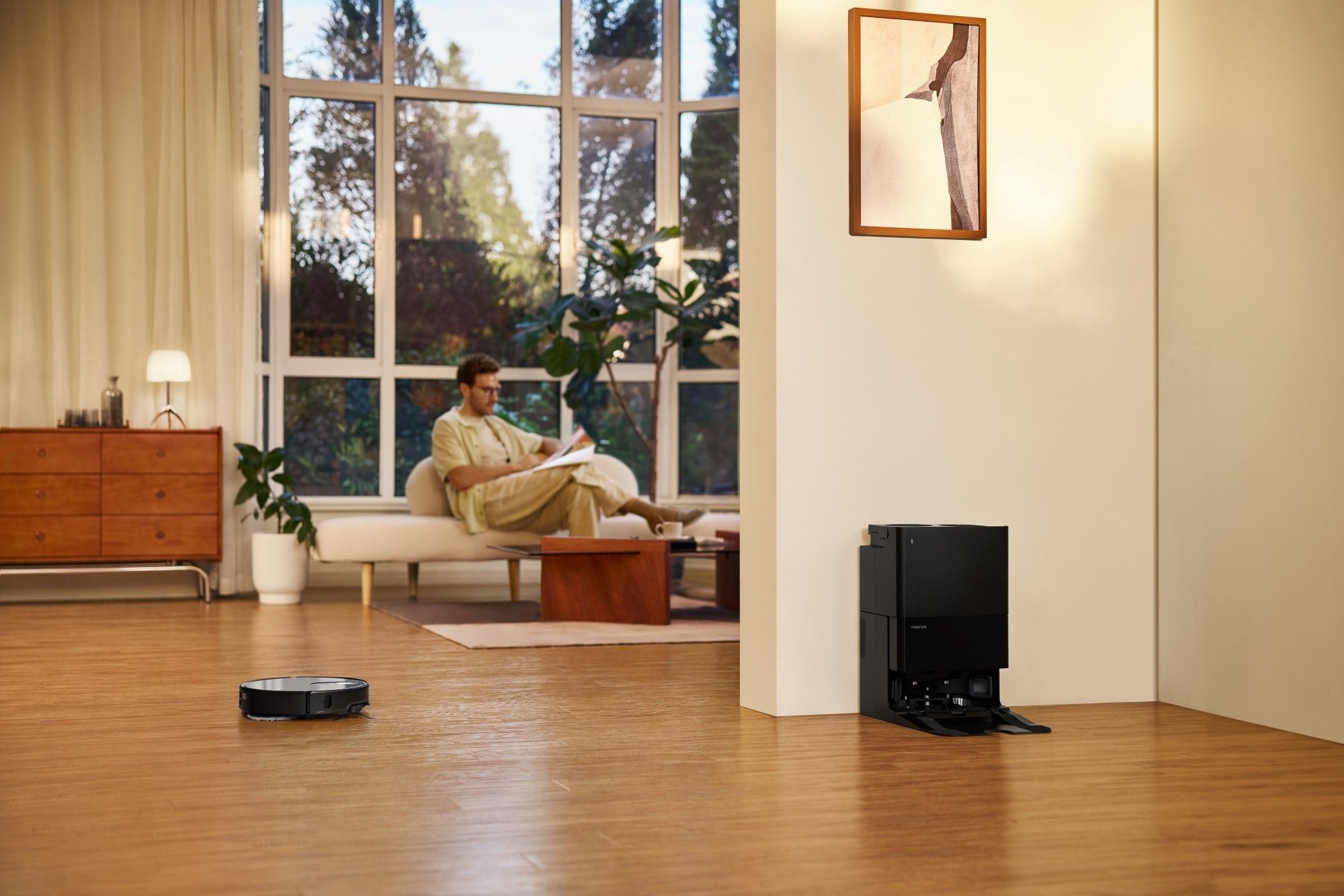 A Man Relaxing While the Roborock Qrevo Slim Cleans Floors