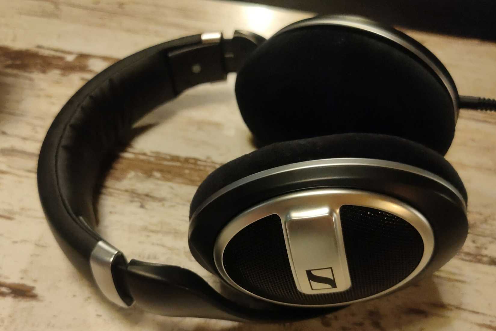 A pair of Sennheiser HD 599SE headphones sitting on a wooden table.