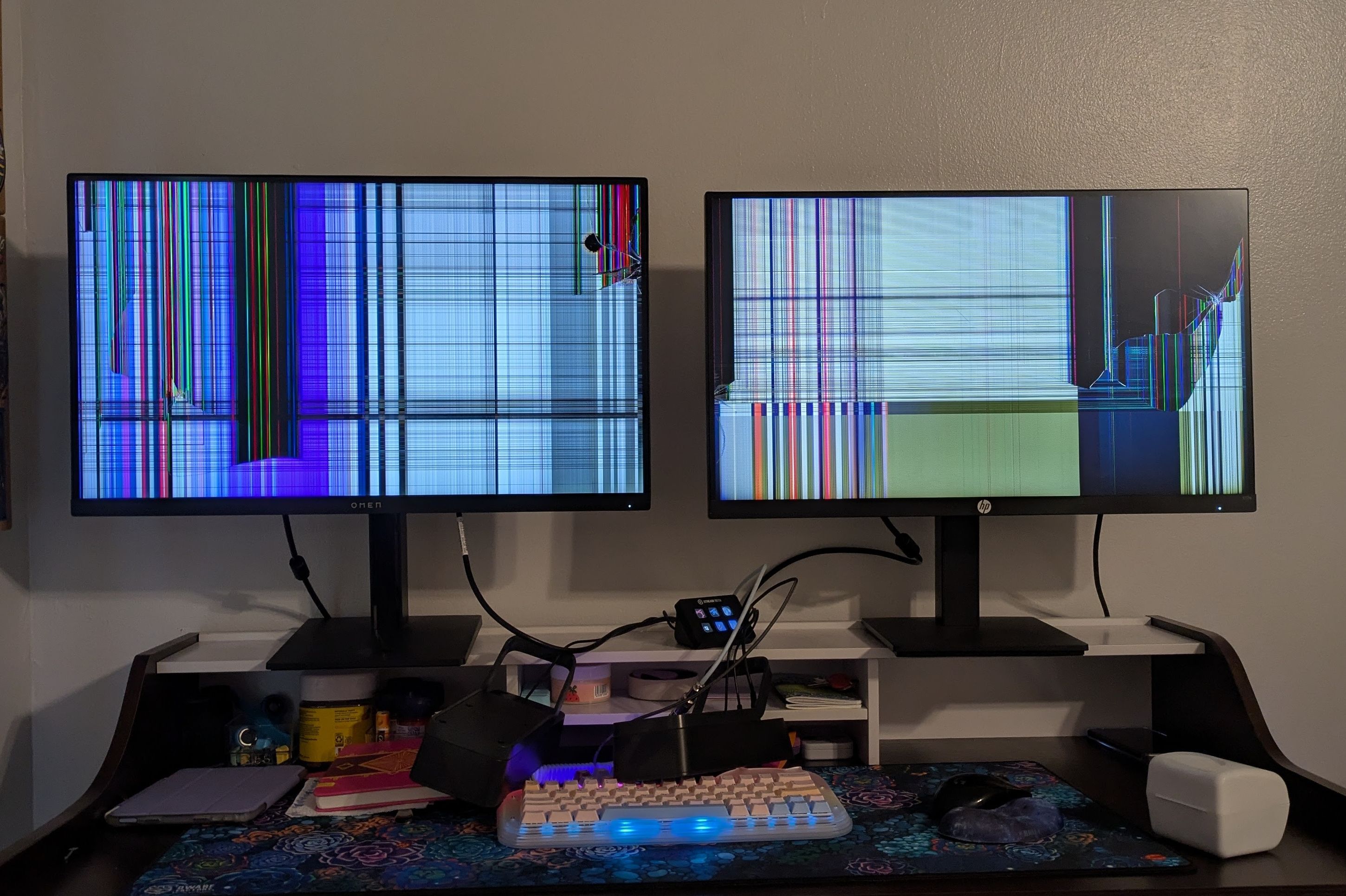 Two broken monitors on a desk.