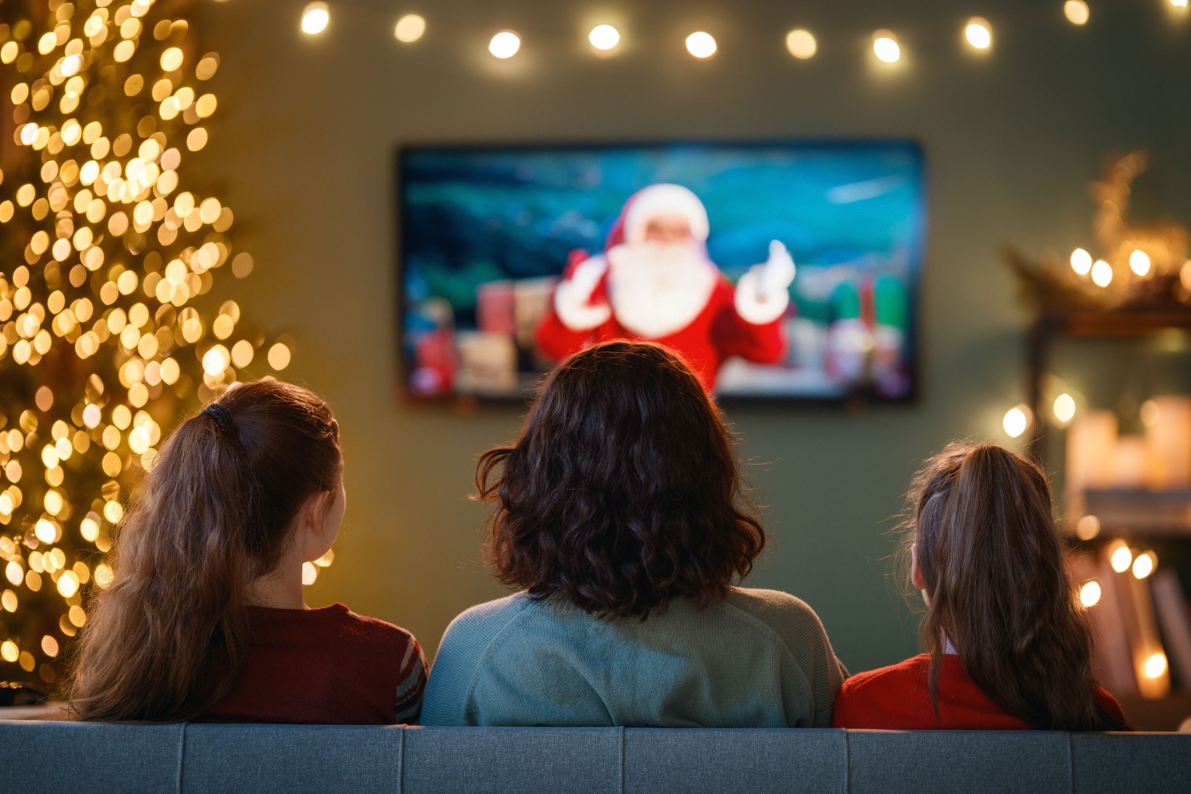 Family sitting in front of the TV at Christmas.-1