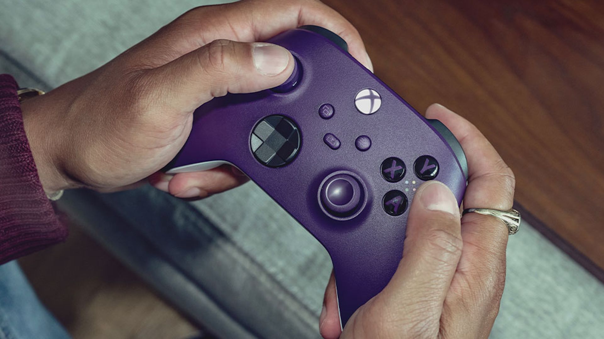 Hands holding a purple Xbox Wireless Controller.