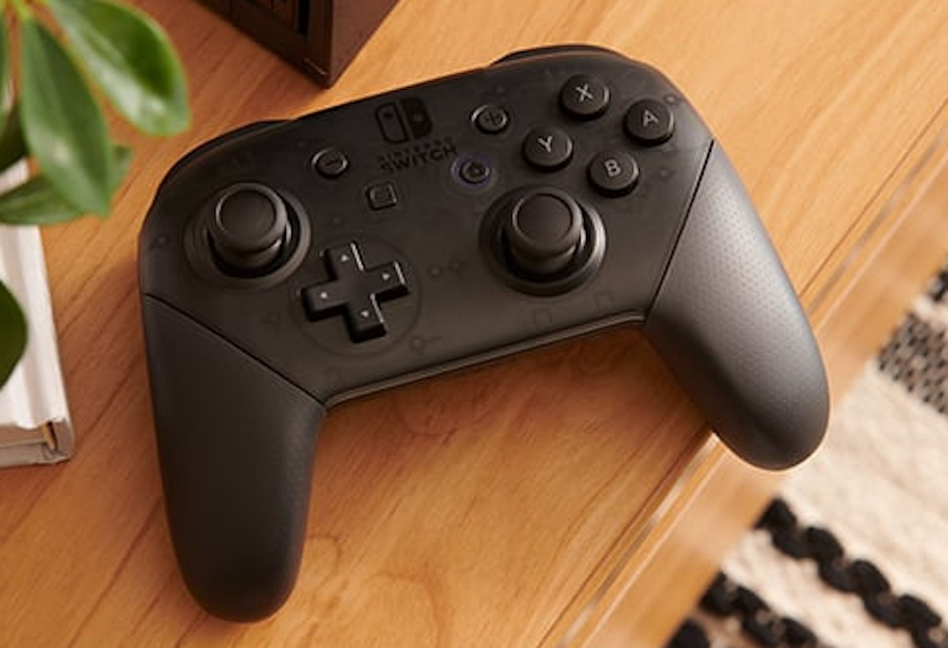 Nintendo Switch Pro Controller laying on a wooden desk.