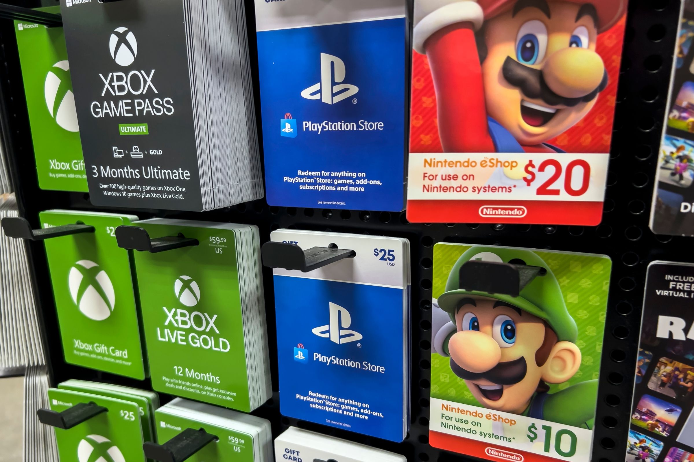 Gift cards for Xbox, PlayStation, and Nintendo platforms on a stand.