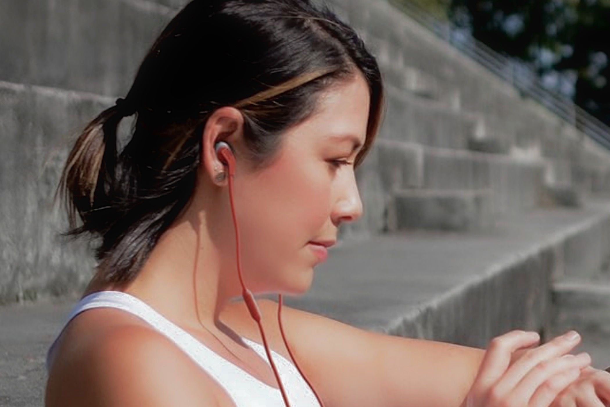 A woman wearing the JBL Endurance Run 2 Wired earbuds while exercising.