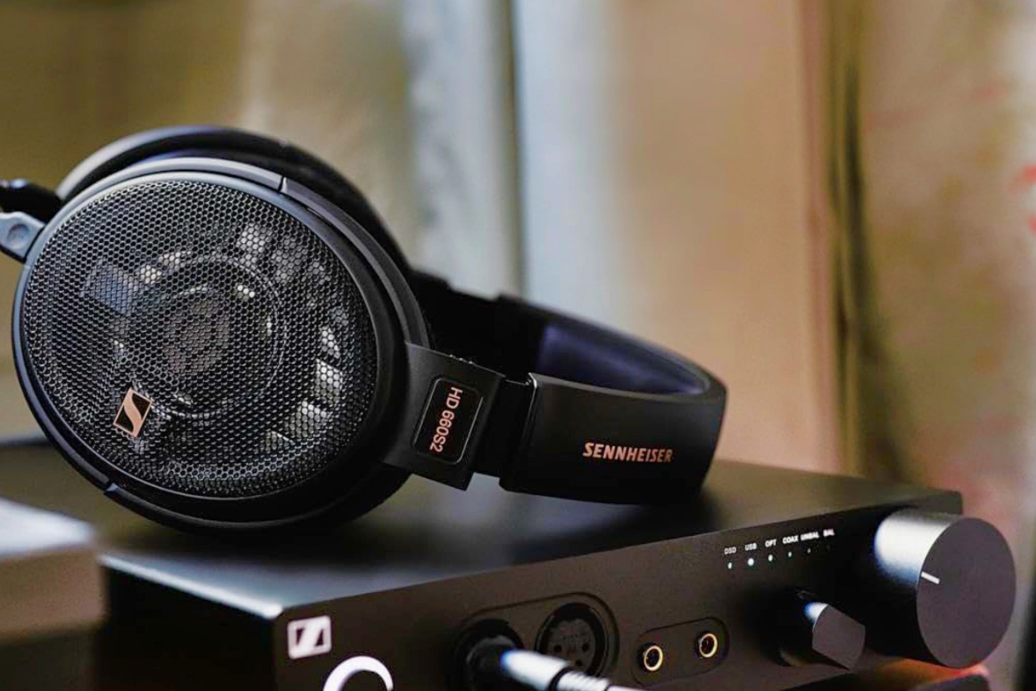 A set of Sennheiser HD 660S2 headphones resting on an amplifier.