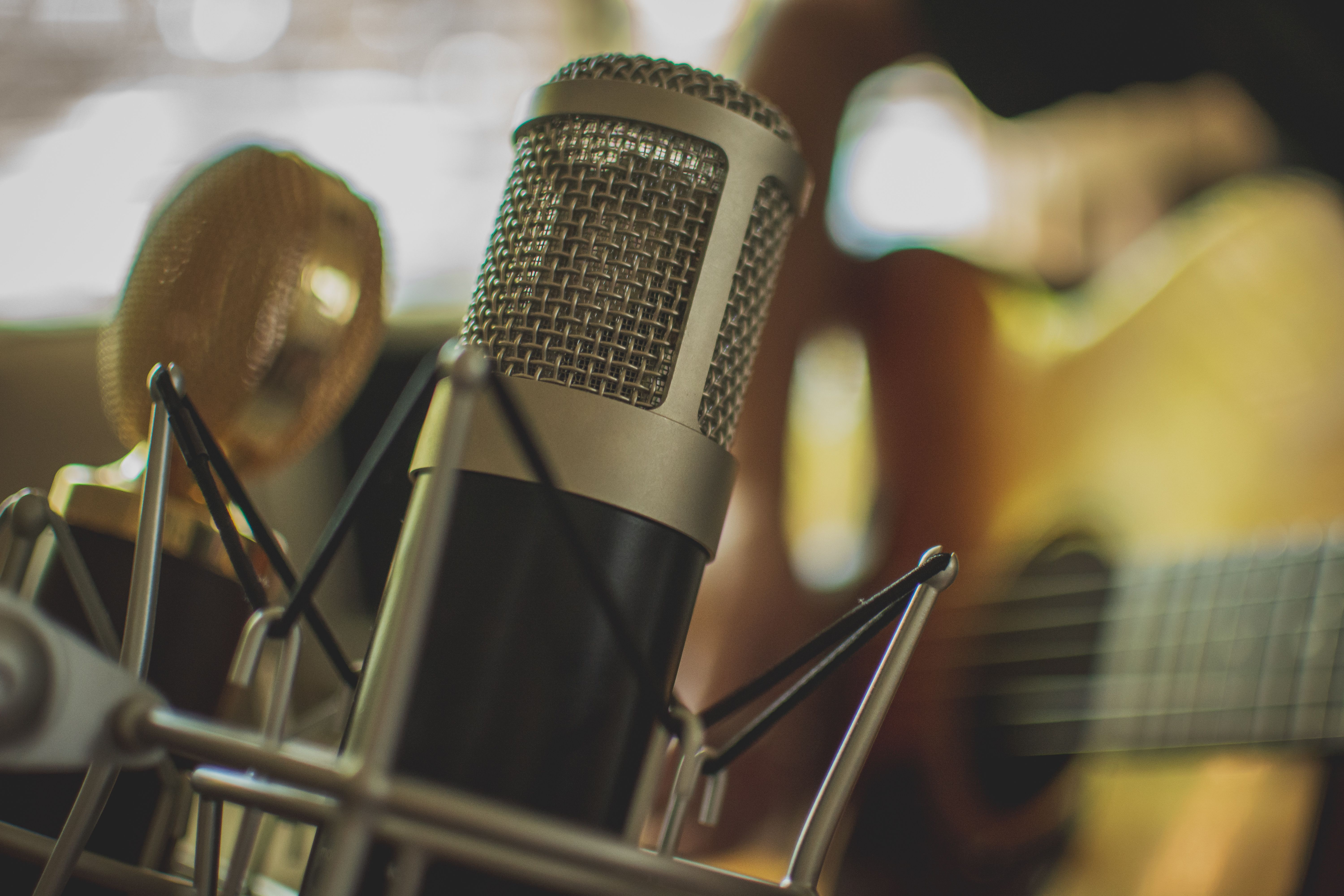 Condenser and ribbon microphone on acoustic guitar in a recording studio session.