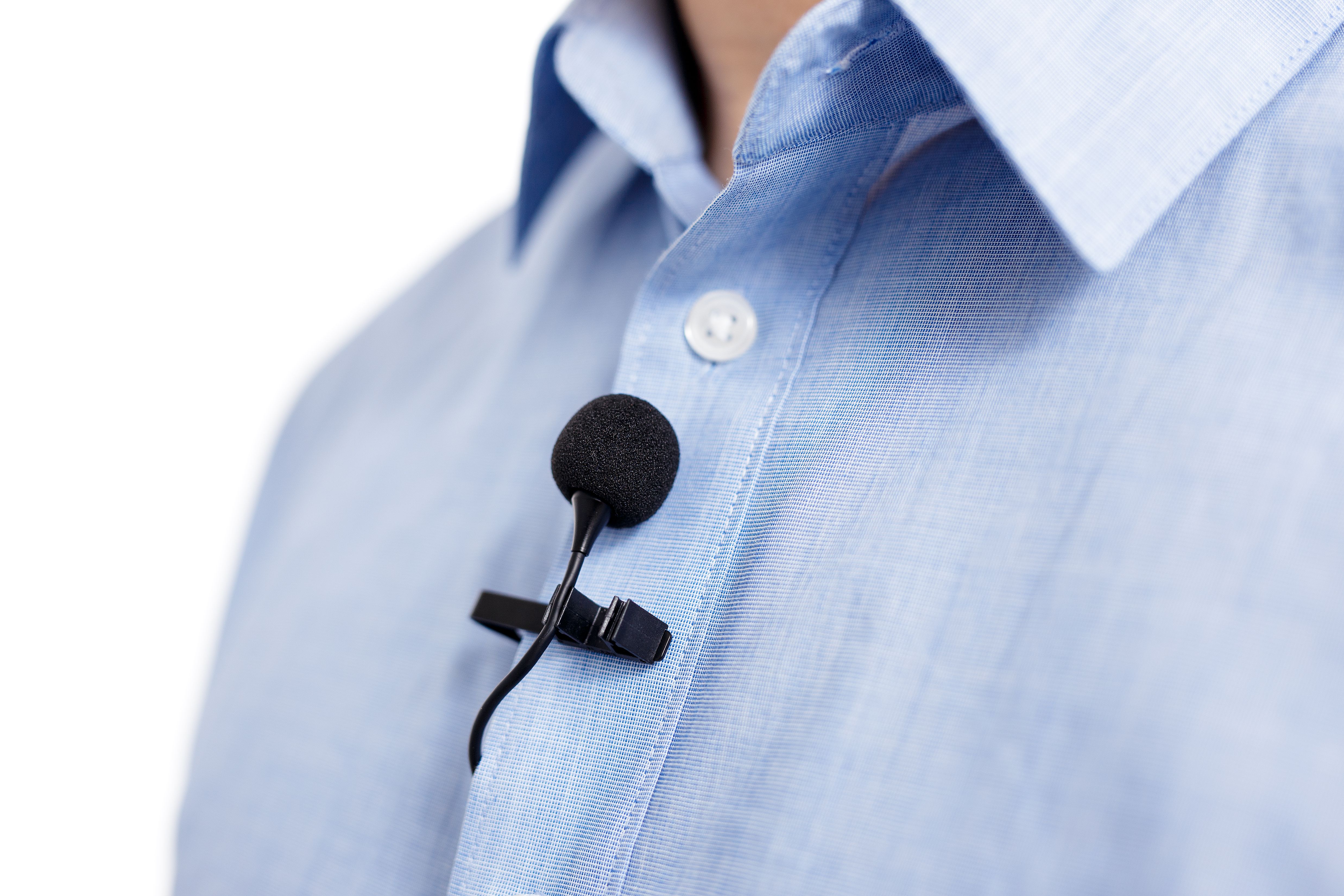 Close up of small lavalier clip-on microphone on male shirt.