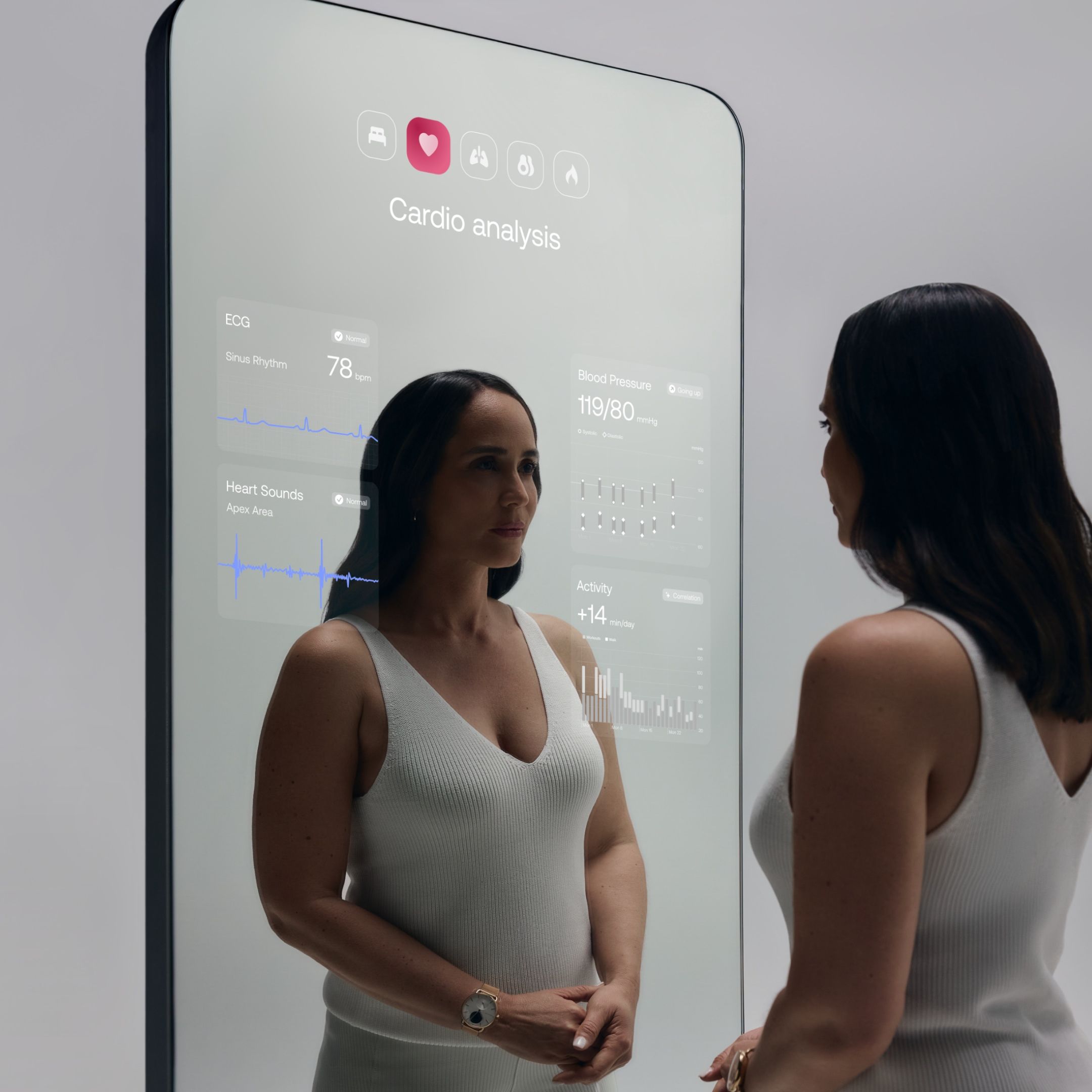 Woman standing in front of a Withings Omnia device, checkin out her health stats on a mirrored interface.