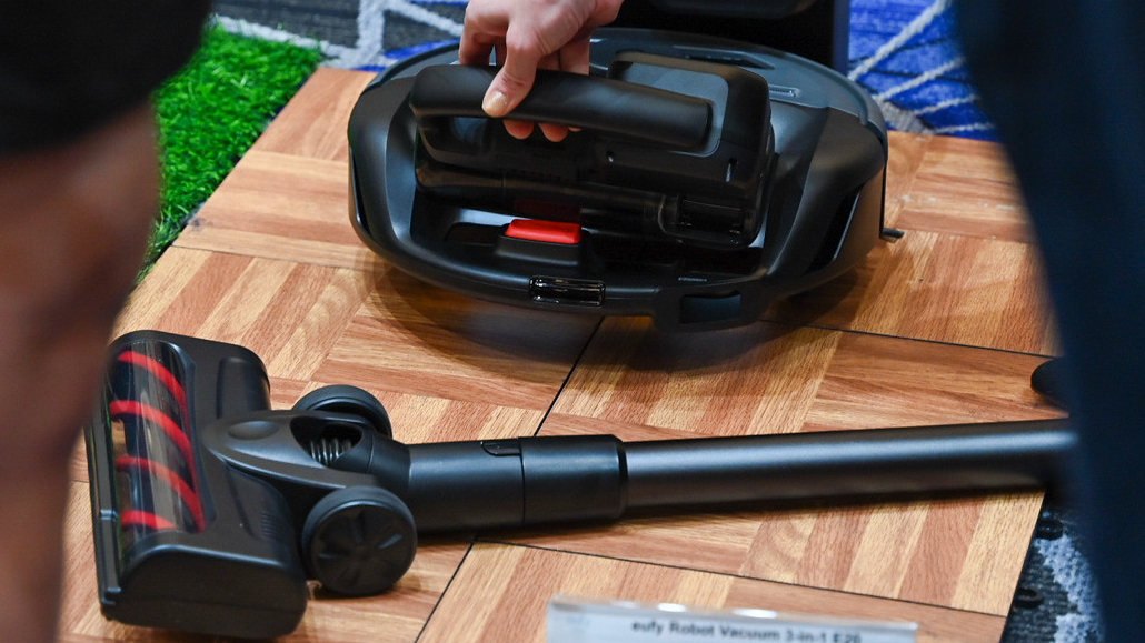 Person Removing the Handheld Section of the Eufy Clean E20 3-in-1- Robot Vacuum at CES 2025