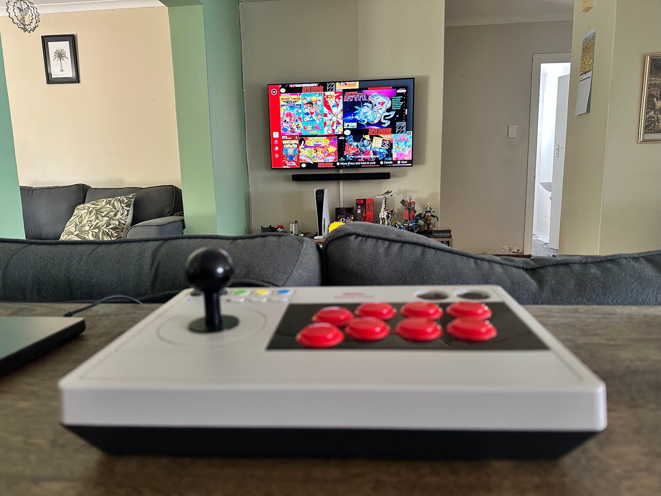 An 8bitDo arcade fight stick with classic Ninendo SNES games on-screen.