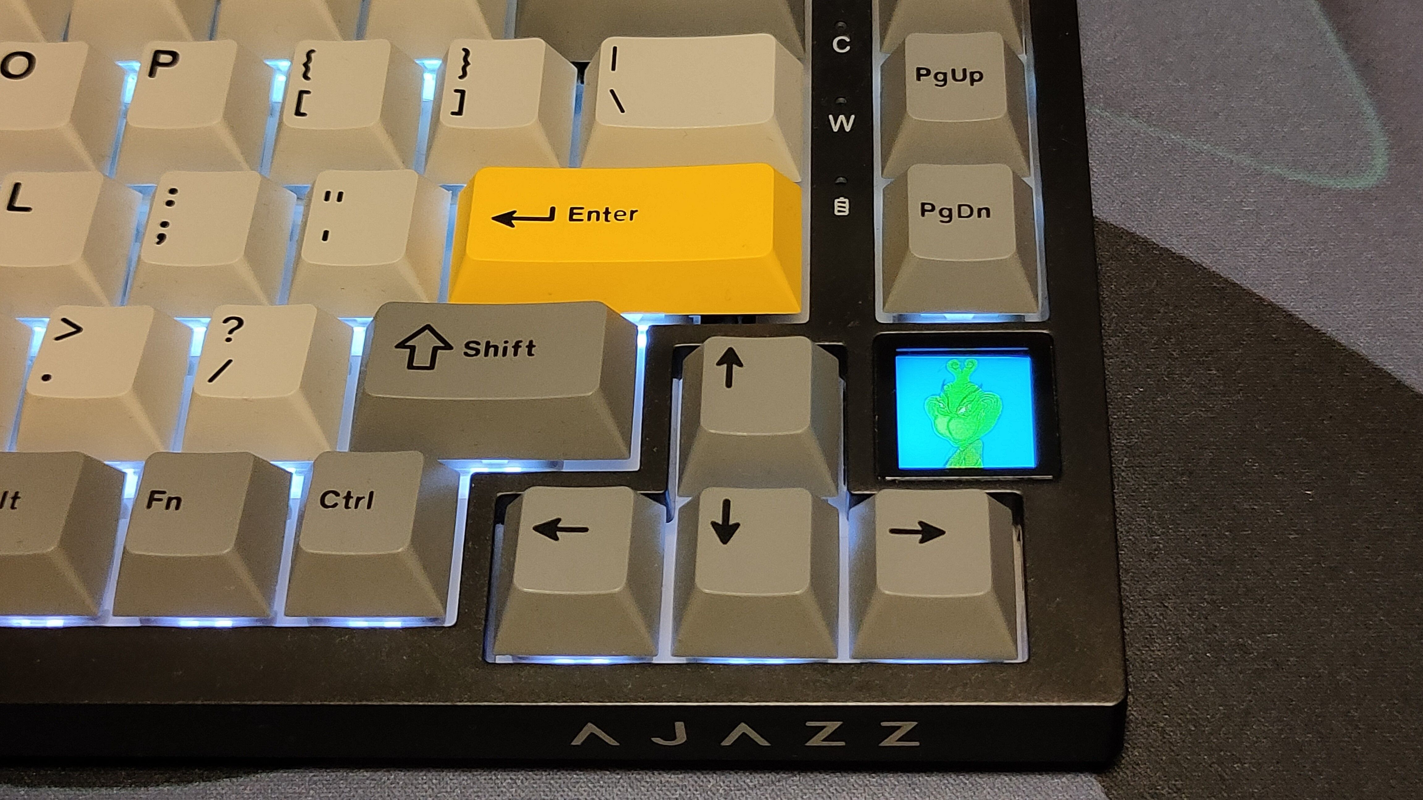 A close-up of the Ajazz AK820 keyboard showcasing a GIF on the built-in screen.