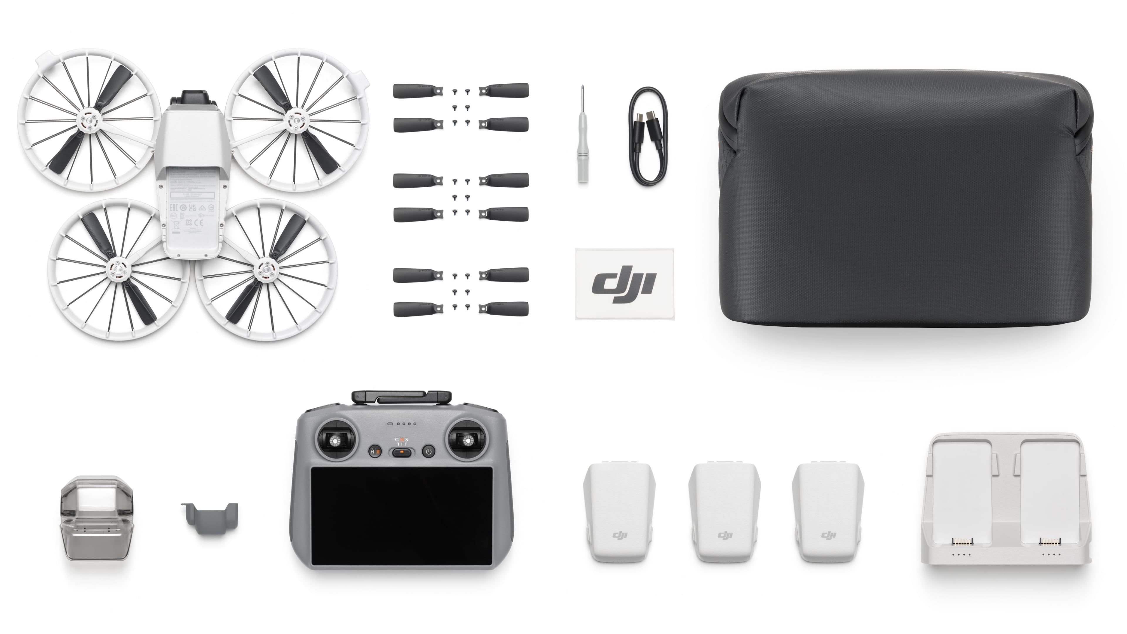 Top down view of the DJI Flip drone parts and batteries detached and laid flat.