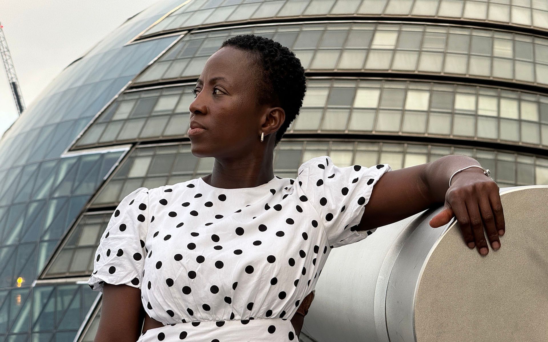 A woman photographed in front of a modern building.