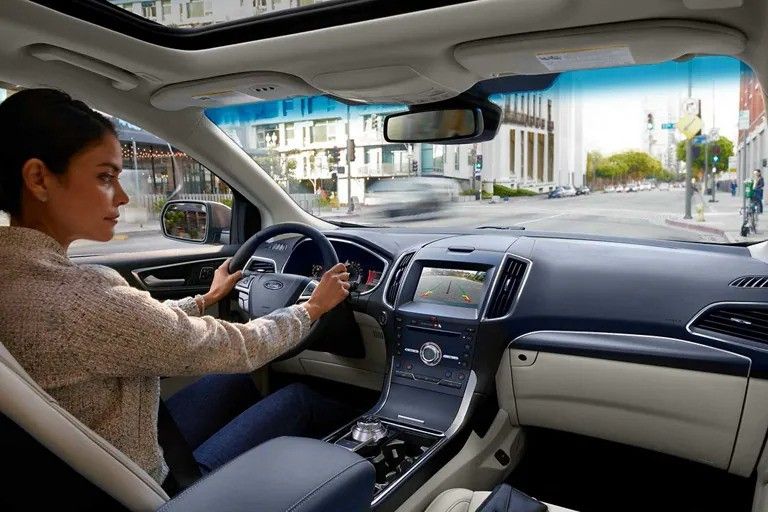 A driver using their car's backup camera to assist with reversing.