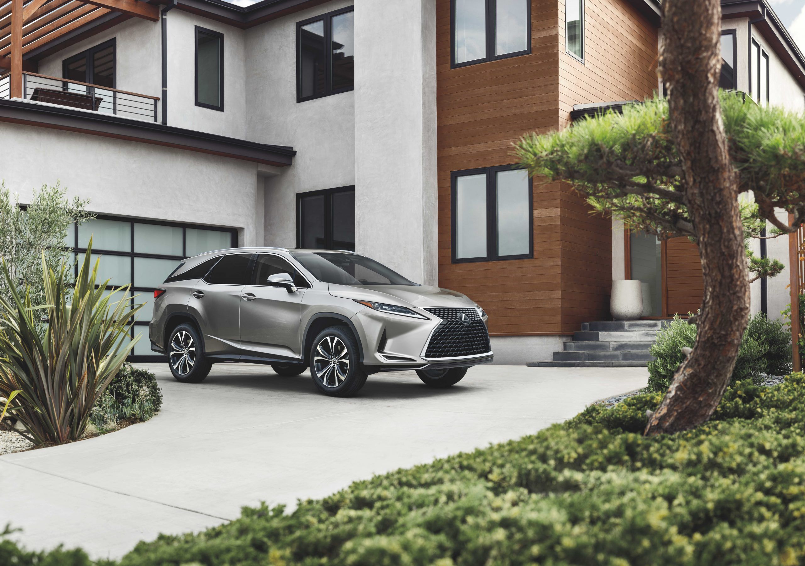 A silver Lexus RX 350L parked on the driveway of a home. 