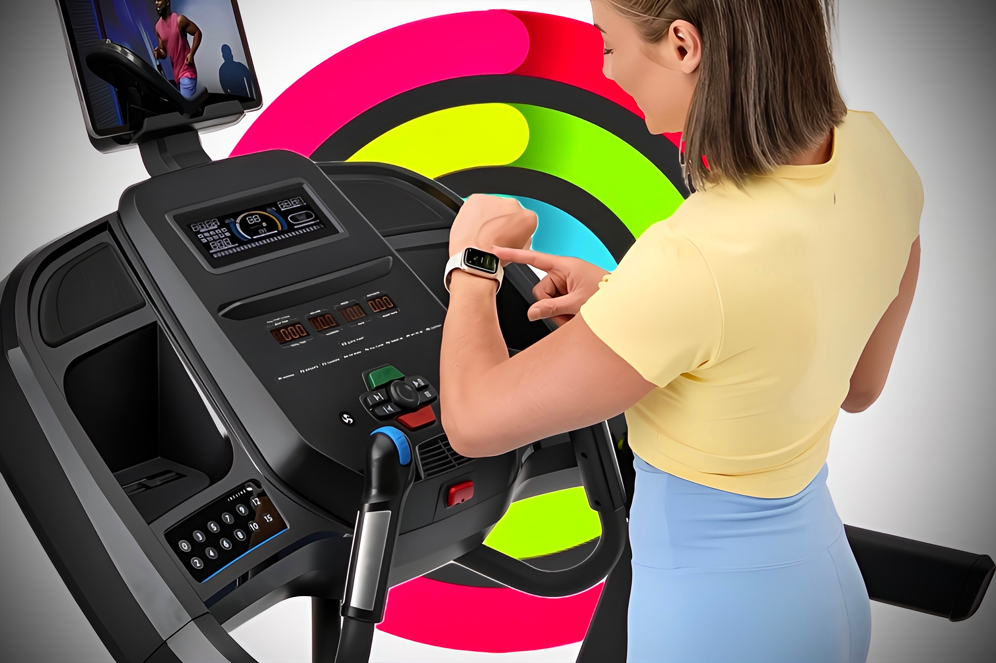 An individual confirming the connection of their Apple Watch to their treadmill in front of closed Activity Rings.