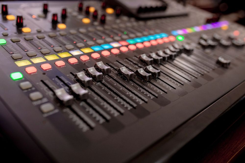 A large professional mixing desk with many faders.