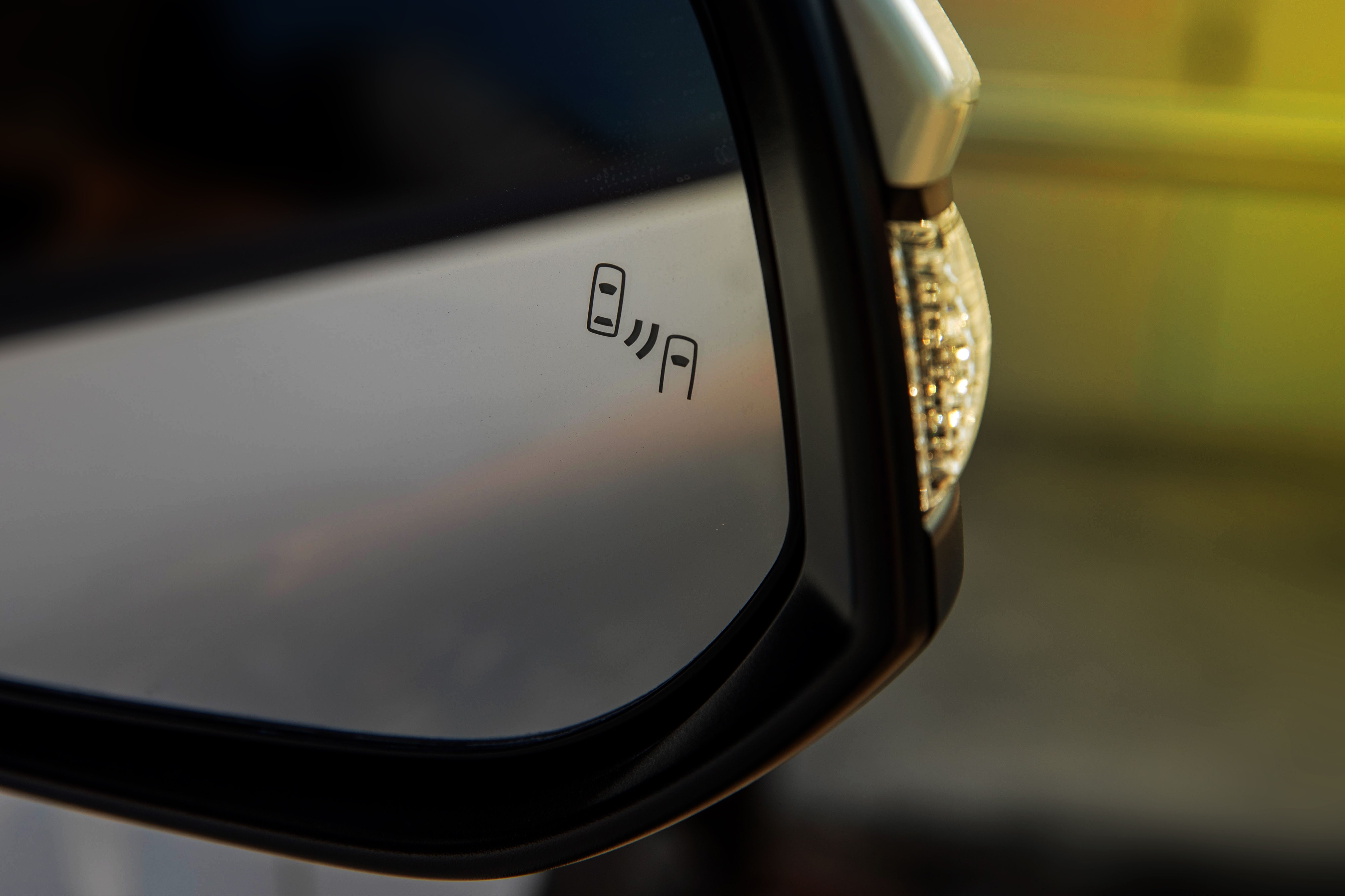 Close-up view of a blind-spot detection system integrated into car side mirrors.