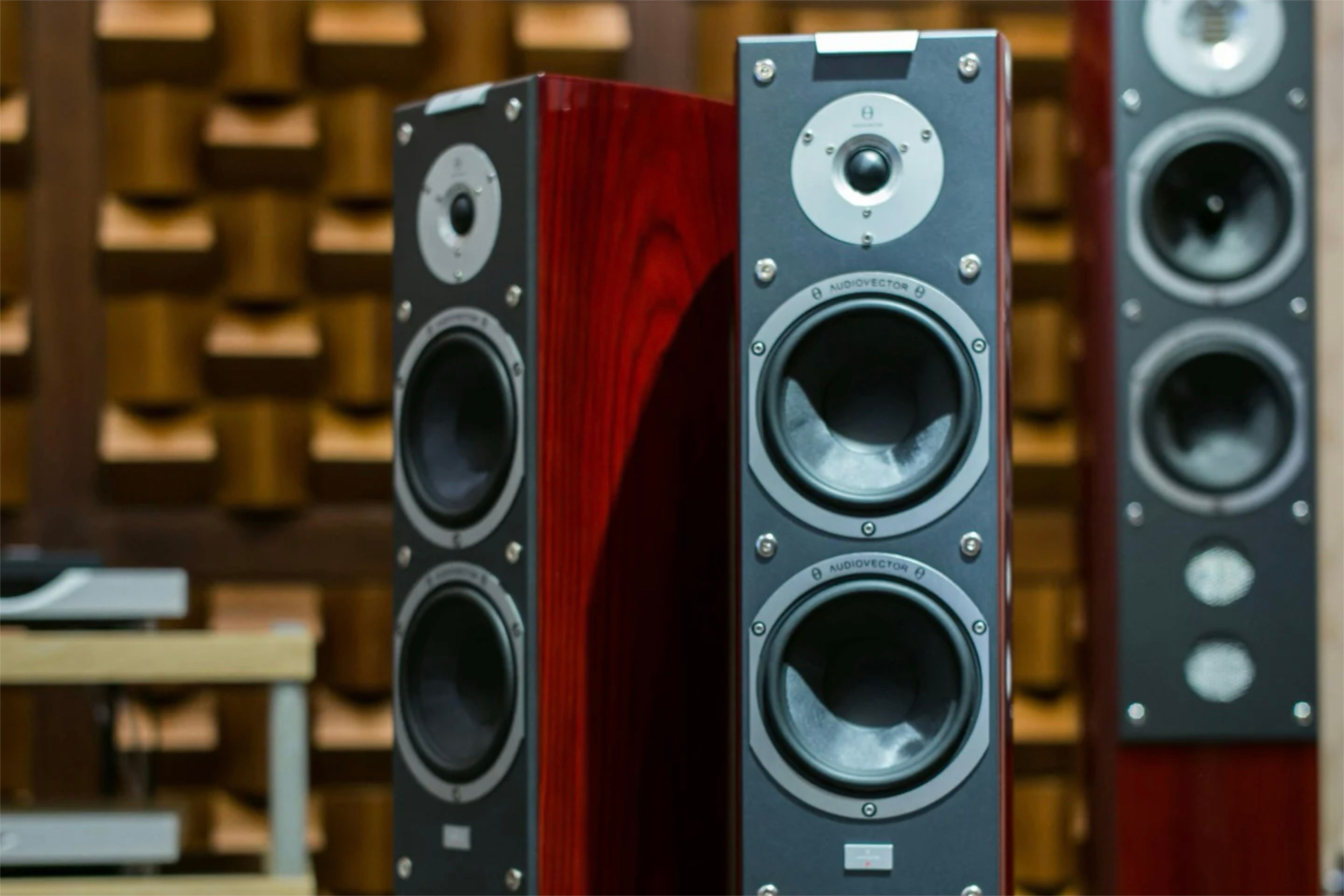 Cherry colored wooden speakers positioned in various directions surrounded by other wooden objects.