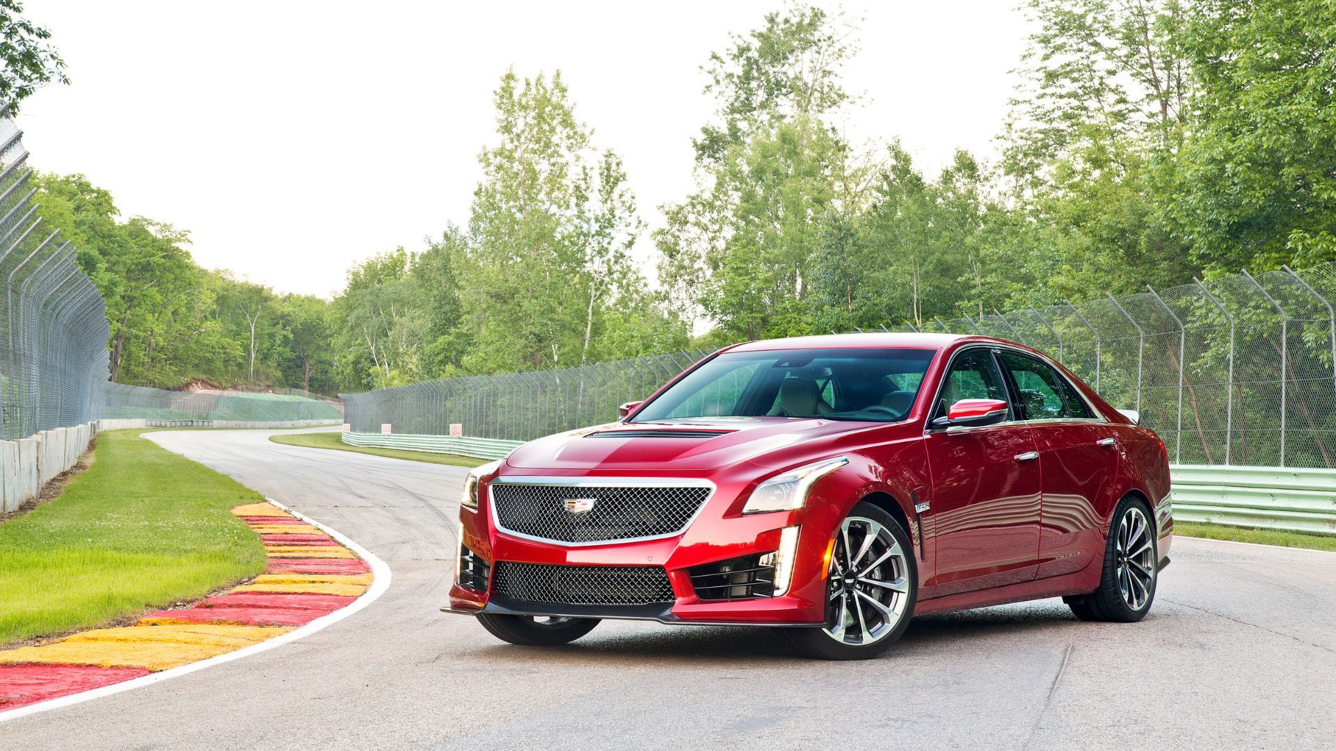 Full view of a red 2016 Cadillac CTS-V parked on the bend of a race track.