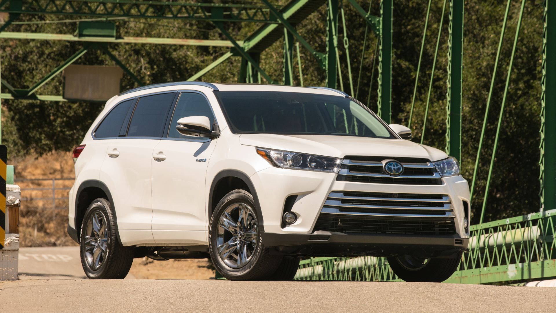 Full view of white 2017 Toyota Highlander Hybrid parked on a bridge.