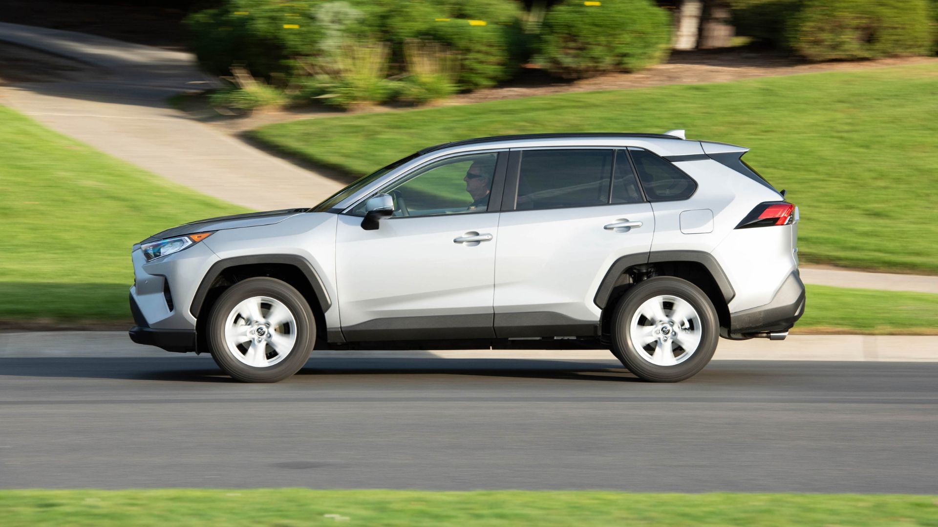 Silver 2019 Toyota RAV4 driving through a residential area.