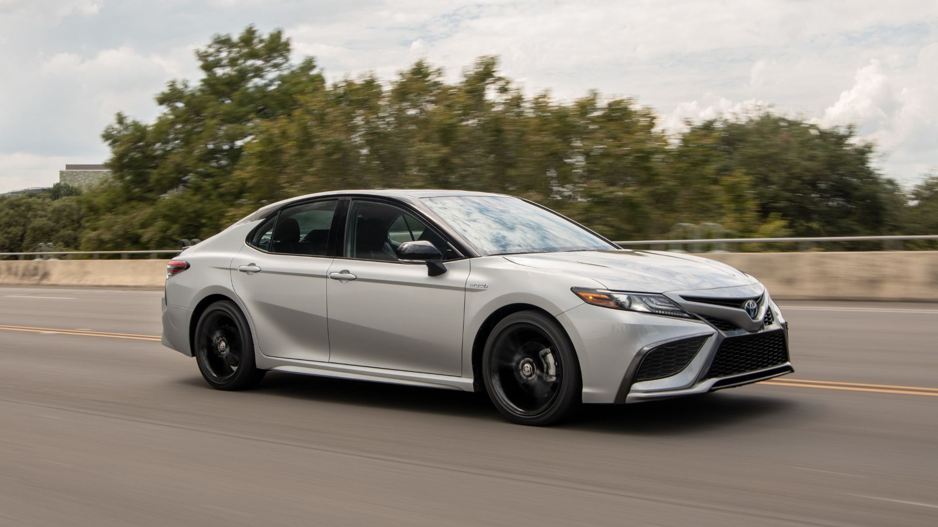 Silvery 2022 Toyota Camry driving along highway.