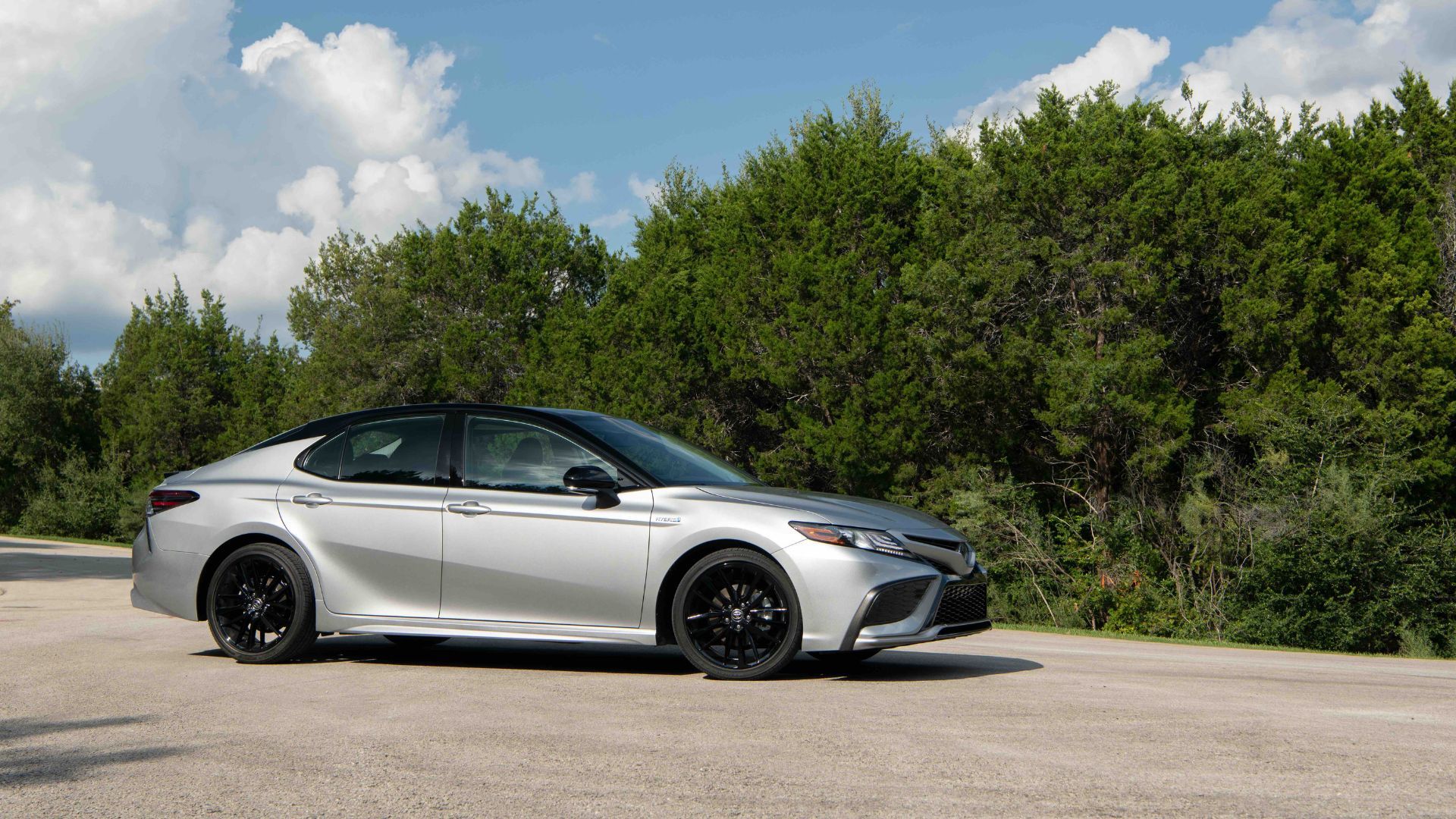 Silver 2022 Toyota Camry parked on tarmac with trees in the background.