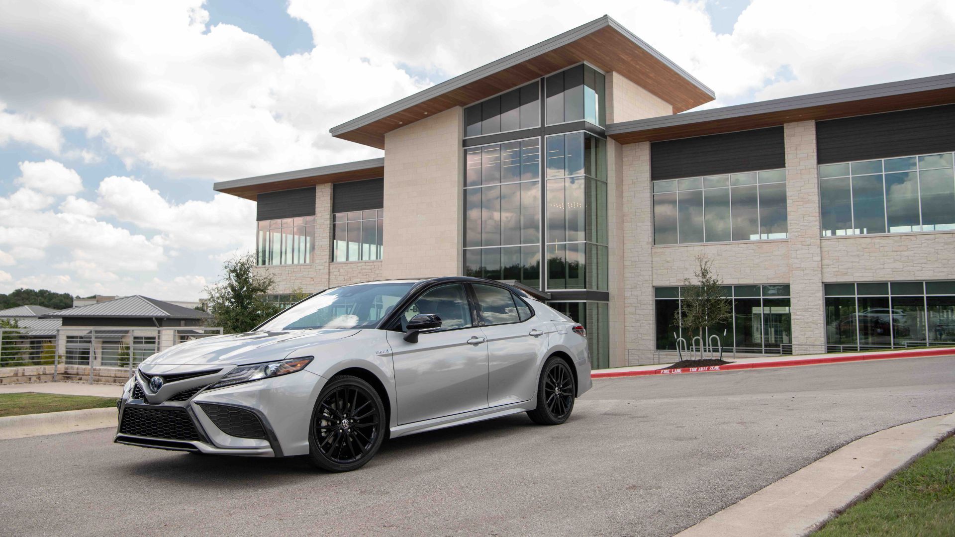 Silver 2022 Toyota Camry parked outside a modern building.