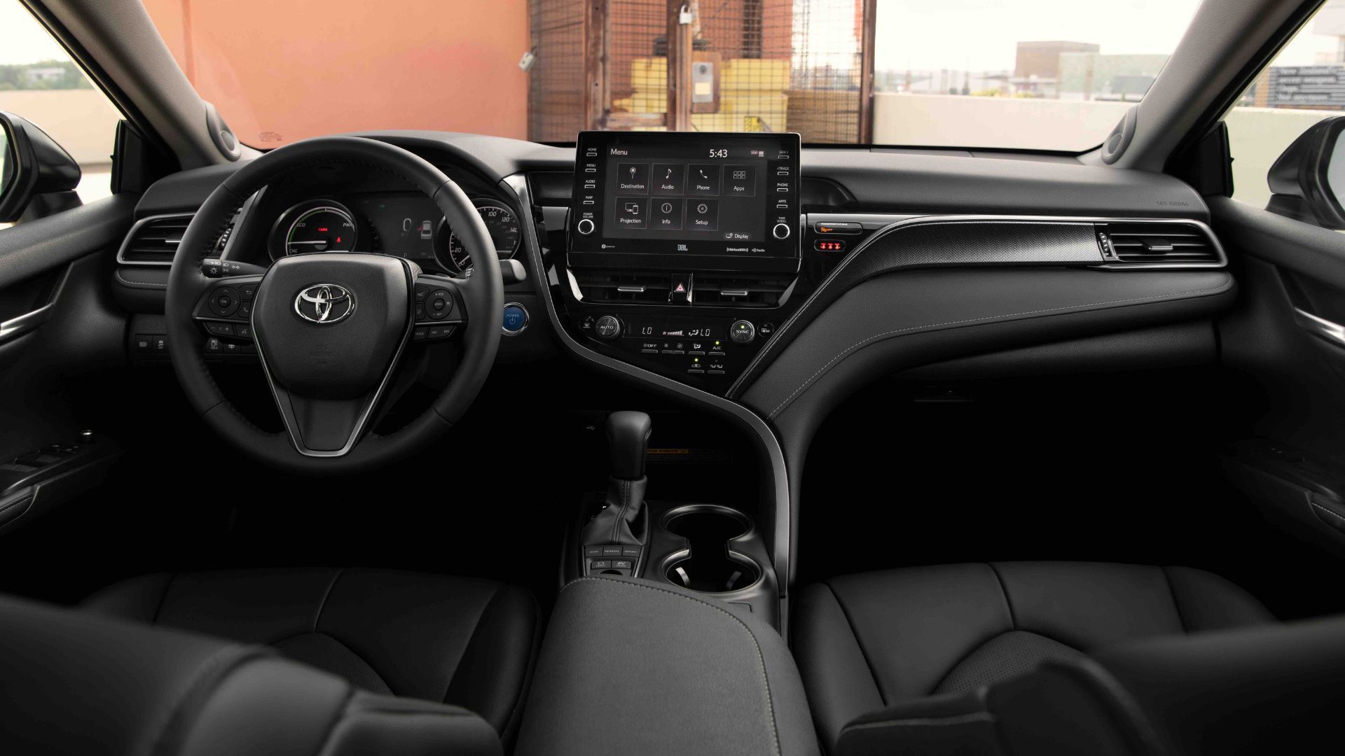 Black interior of 2022 Toyota Camry showing dashboard with steering wheel and infotainment screen.