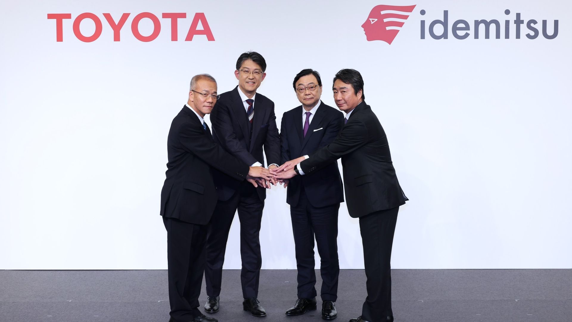 Executives from Toyota and Idemitsu shaking hands