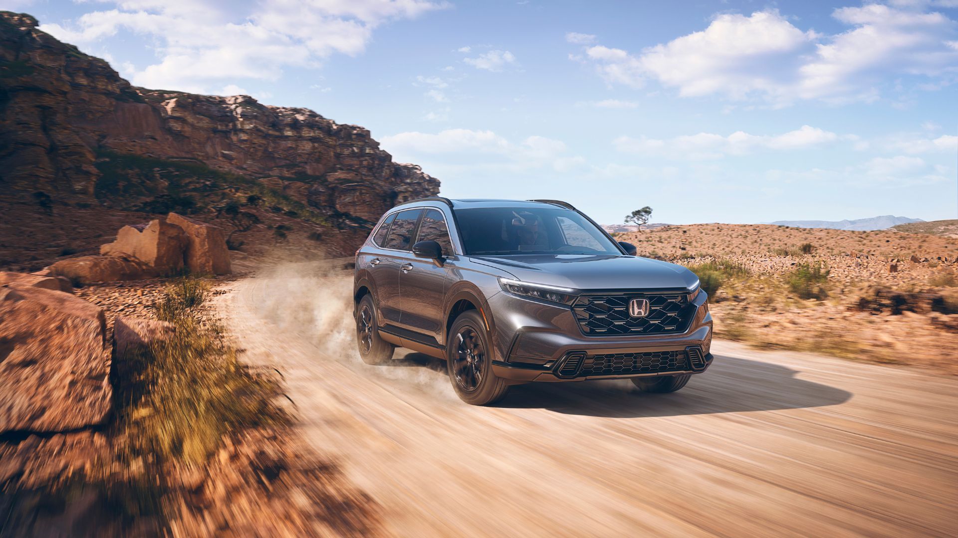 Gray 2024 Honda CR-V Sport off-roading on a dirt track.