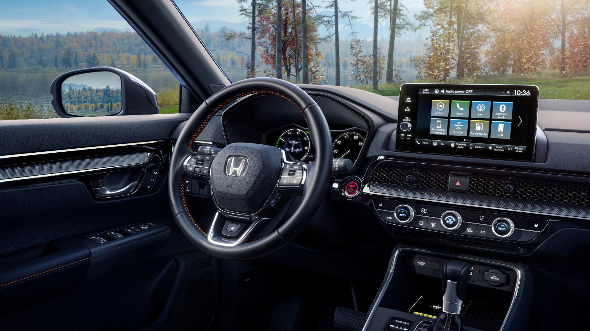 Interior of 2023 Honda CR-V Sport Touring showing steering wheel and infotainment screen.