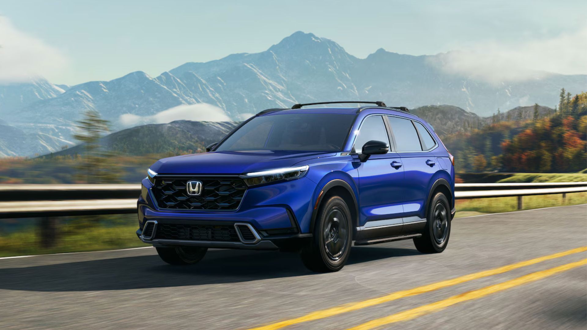 Blue Honda CR-V Hybrid driving on a country road.